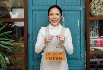 Small business owner with an open shop sign