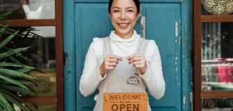 Small business owner with an open shop sign