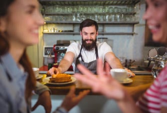 waiter serving cup coffee sweet food customers