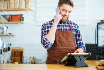 Bearded man holds phone as he looks at POS v3 ScaleMaxWidthWzEwMjRd