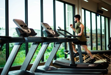 Man running on gym treadmill