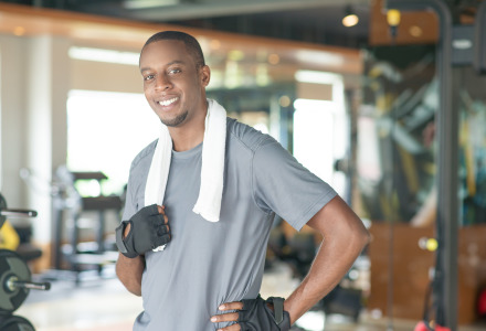 smiling sporty black man wearing towel around neck