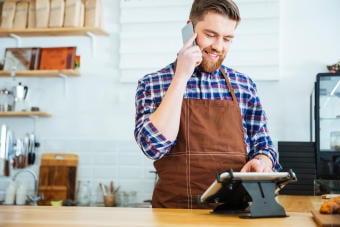 Bearded man holds phone as he looks at POS v3